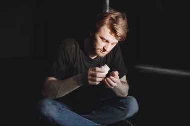 Haplı adam yerde oturuyor.