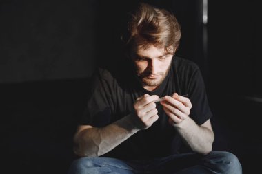 Uyuşturucu için şırınga tutan keş bir adam.