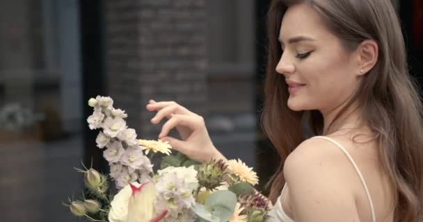 Happy elegan wanita muda dengan bunga di kota — Stok Video