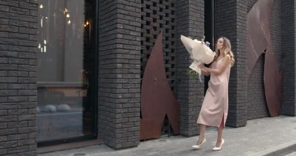 Young beautiful girl holding a bouquet of flowers — Vídeo de Stock