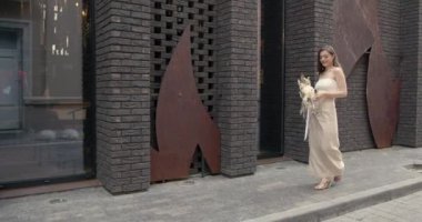 Genç güzel kız elinde bir buket çiçek tutuyor.