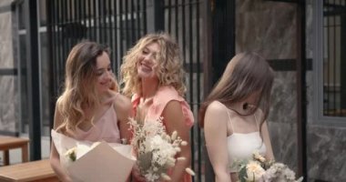 Şehirde poz veren üç mutlu bayan.