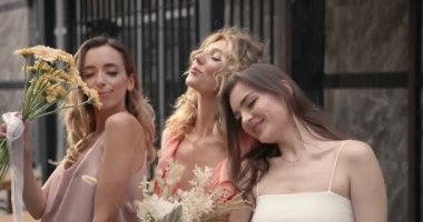 Şehirde poz veren üç mutlu bayan.