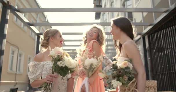Три щасливі дами з букетами позує в місті — стокове відео