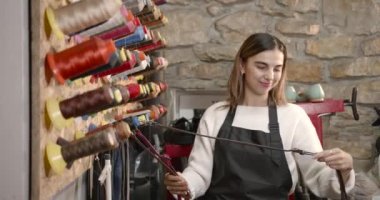 Bir mağazada elbise dikmek için kıyafet seçen bir kadın.