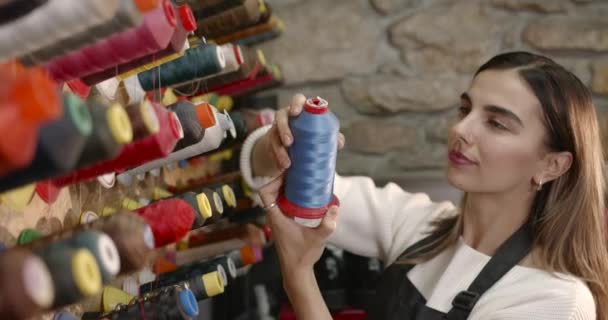 Woman choosing threads for dressmaking in a shop — Vídeo de Stock