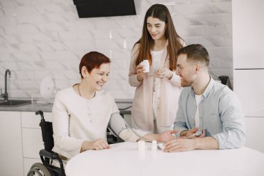 Engelli anneye yardım eden çift tansiyonunu ölçüyor