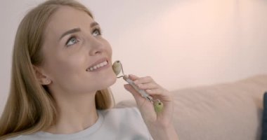 Hamile bir kadın tekerlekli sandalyeyle yüz masajı yapıyor.