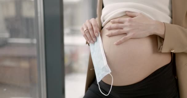 Femme enceinte tenant un masque médical près du ventre — Video