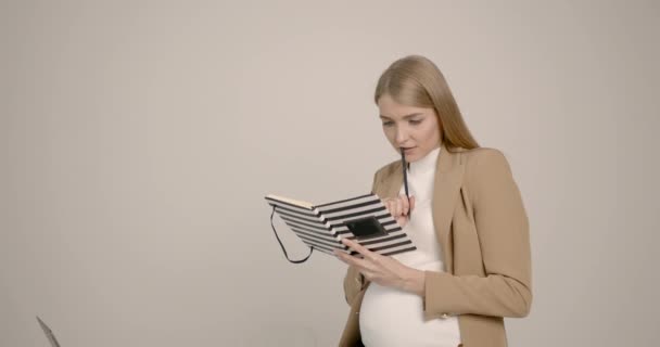 Стильна молода вагітна жінка читає сидячи в офісі — стокове відео