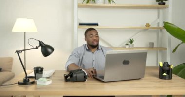 Genç siyahi adam ofiste sanal gerçeklik gözlüğü takıyor.