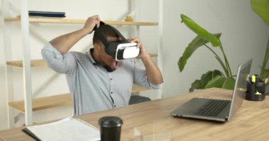 Genç siyahi adam ofiste sanal gerçeklik gözlüğü takıyor.