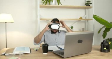 Genç siyahi adam ofiste sanal gerçeklik gözlüğü takıyor.