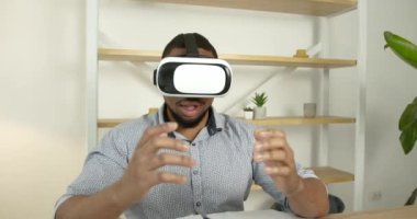 Genç siyahi adam ofiste sanal gerçeklik gözlüğü takıyor.