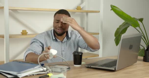 Genç siyahi adam ofiste kan basıncını ölçer. — Stok video