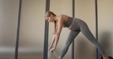 Pretty young pregnant model doing pilates on a machine