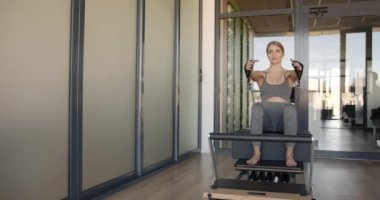 Makinede pilates yapan hamile bir model.
