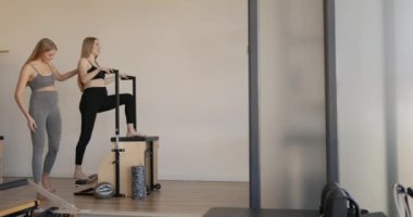 Eğitmenle pilates yapan hamile bir kadın.