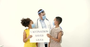 Aşılanmış siyah çocuklar ve beyaz arka planda pankartı olan bir doktor.