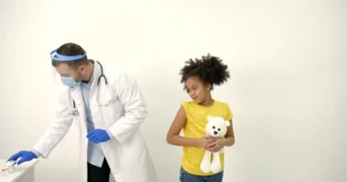 Erkek çocuk doktoru siyahi bir çocuğa aşı yapıyor.