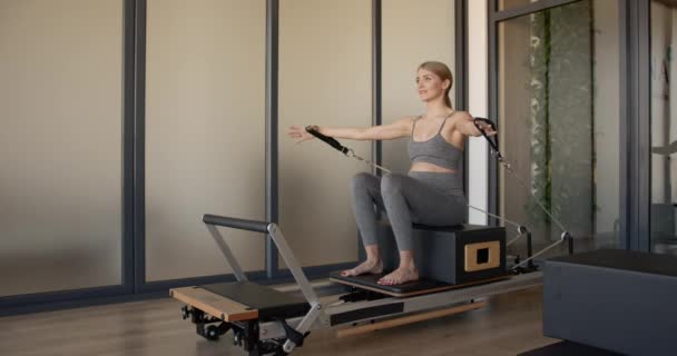 Pretty young pregnant model doing pilates on a machine — ストック動画