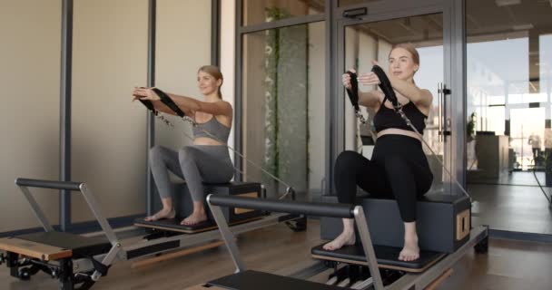 Two fit pregnant woman work on Pilates machines — Stock Video
