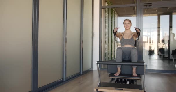 Pretty young pregnant model doing pilates on a machine — Vídeos de Stock