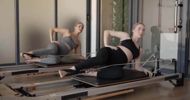 Two fit pregnant woman work on Pilates machines — Stock Video