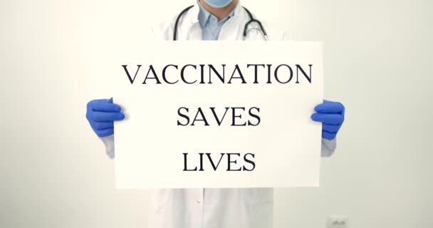 Male doctor holding banner vaccination saves lifes — Stock Video