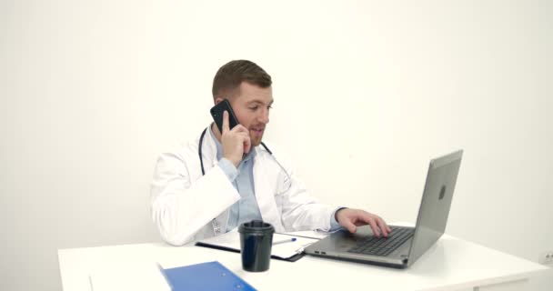 Médico masculino trabalha com laptop no escritório — Vídeo de Stock