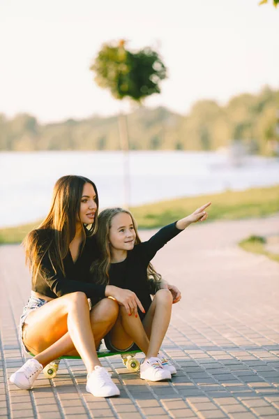 Mother and daughter having fun while skating at park — Zdjęcie stockowe