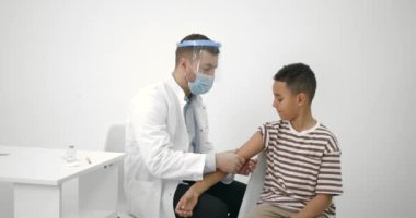 Erkek çocuk doktoru siyahi bir çocuğa aşı yapıyor.
