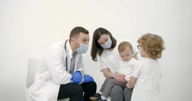 Anne ve çocuklar pediatri muayenehanesinde.