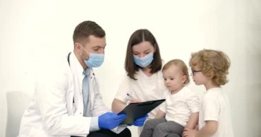 Anne ve çocuklar pediatri muayenehanesinde.