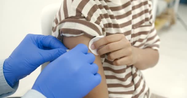 Male pediatrician giving a vaccine shot to a black kid — Video