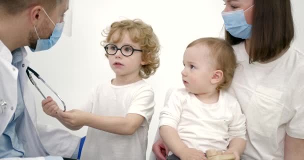 Mãe com crianças em check-up no escritório do pediatra — Vídeo de Stock