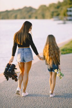 Anne ve kızı parkta kayarken eğleniyorlar.