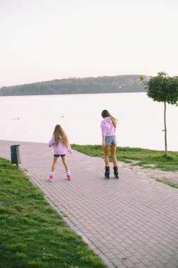 Anne ve kızı göl kenarında paten kayıyorlar.