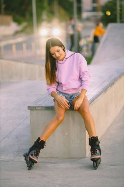 Parkta paten kayan çekici bir kadın.