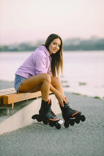 Young attractive woman with roller skates in park — Foto de Stock