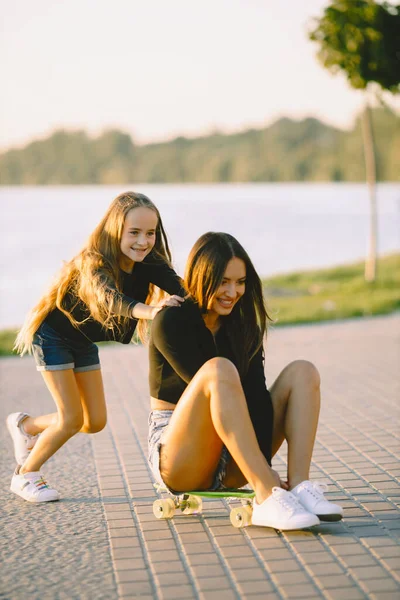 Matka a dcera se baví při bruslení v parku — Stock fotografie