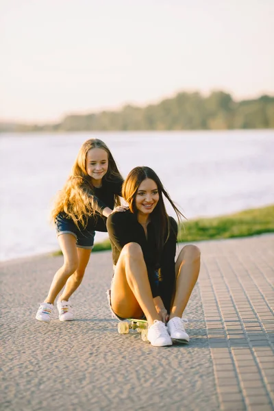 Mother and daughter having fun while skating at park — Stock fotografie