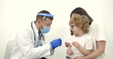 Annesi çocuk doktorunda aşı yaptırıyor.