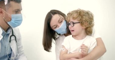 Annesi çocuk doktorunda aşı yaptırıyor.