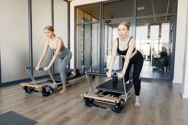 İki genç hamile kadın özel bir ekipman üzerinde alıştırma yapıyor.