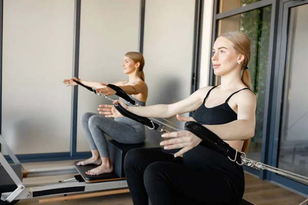 Two young pregnant women doing excercises on a special equipment — Fotografia de Stock