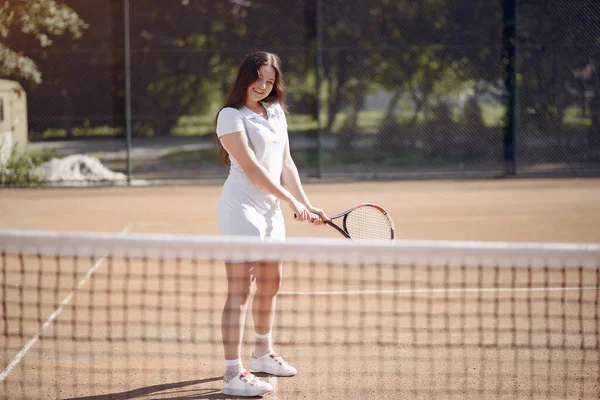 Caucasian female tennis player playing on the court outdoors — Stock fotografie