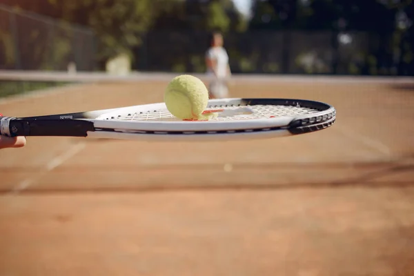 Cropped photo of racket with ball and blurred second player — Stockfoto