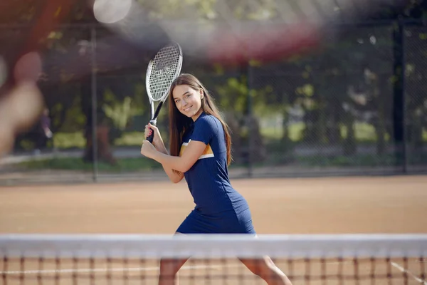 Caucasian female tennis player playing on the court outdoors — Stock fotografie