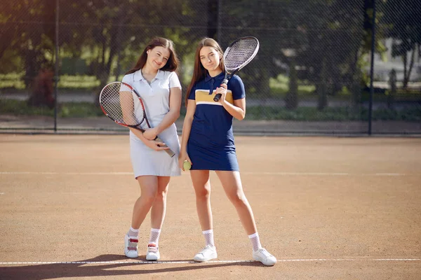 Two female tennis players on a tennis court posing for a photo — Stock fotografie